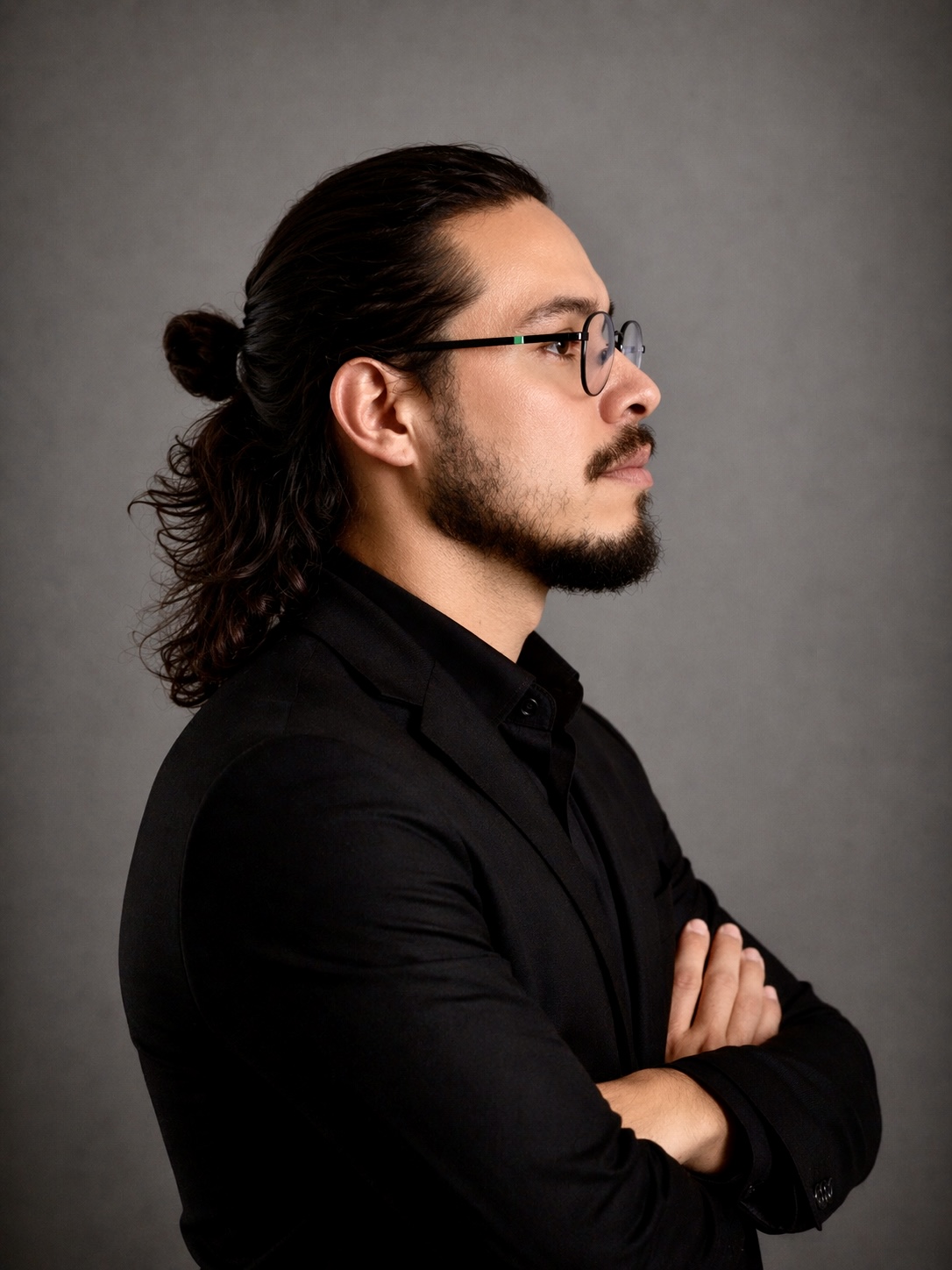 Filipe Ferreira de perfil, hipnoterapeuta, em traje escuro e óculos